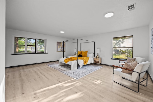 bedroom featuring visible vents, baseboards, and wood finished floors