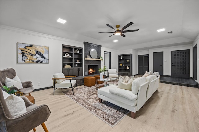 living area with visible vents, baseboards, wood finished floors, and built in shelves