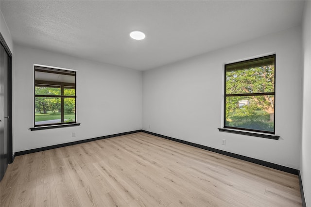spare room with light wood-style floors and baseboards