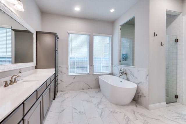 full bathroom featuring a healthy amount of sunlight, tile walls, a shower stall, and marble finish floor