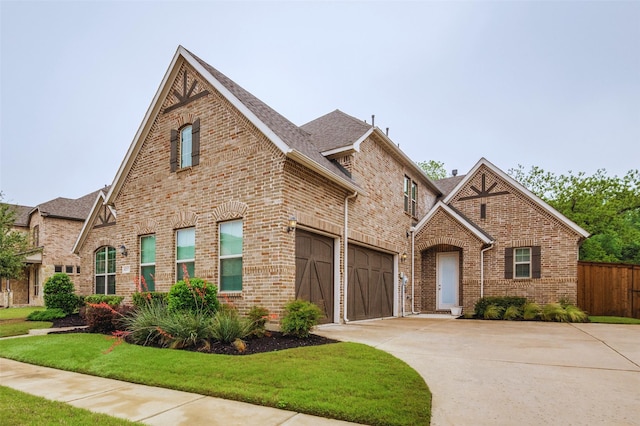 view of front of property with fence, a front yard, driveway, and brick siding
