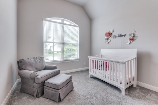 carpeted bedroom featuring baseboards, a crib, and lofted ceiling