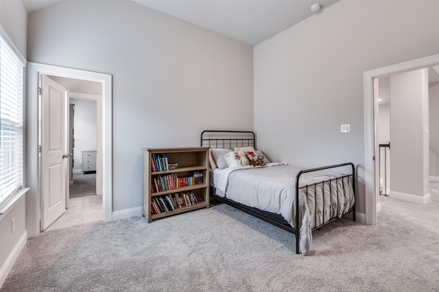 carpeted bedroom with baseboards and vaulted ceiling