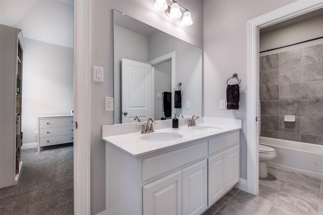 full bathroom with double vanity, a sink, and toilet