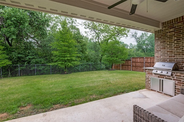 view of yard featuring a fenced backyard, a patio, ceiling fan, and exterior kitchen