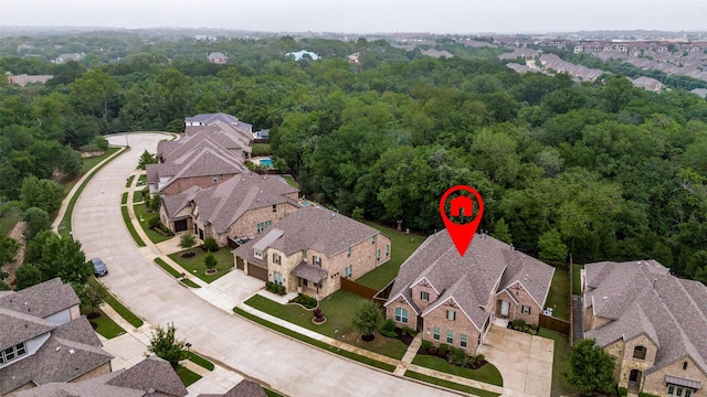 drone / aerial view featuring a view of trees and a residential view