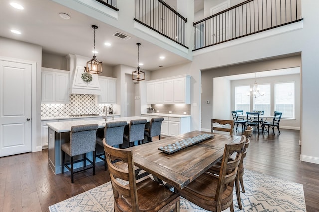 dining space featuring dark wood-style flooring, an inviting chandelier, recessed lighting, baseboards, and visible vents