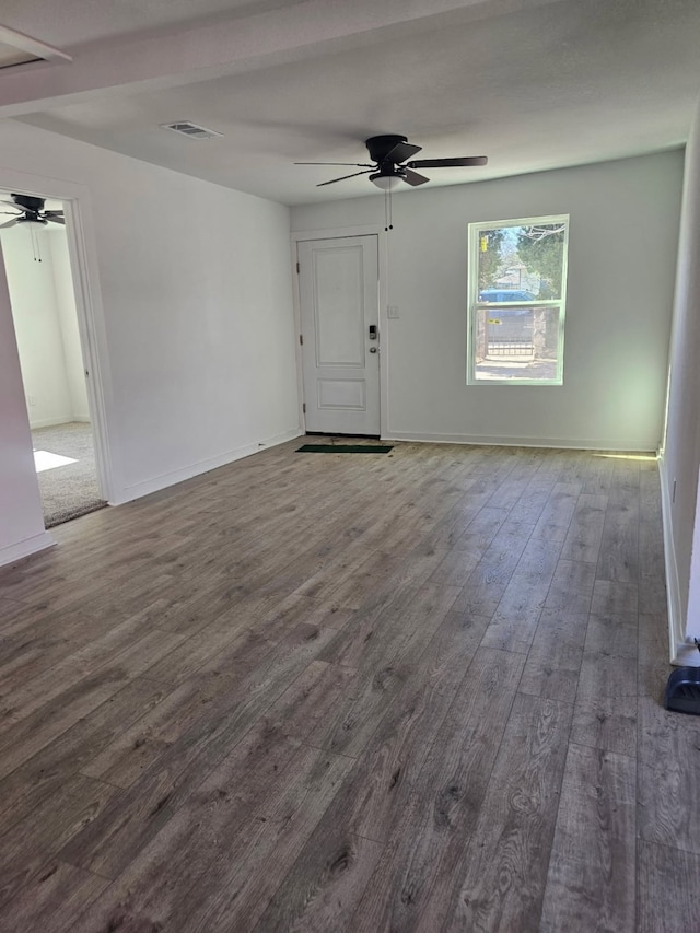 unfurnished living room featuring baseboards, ceiling fan, visible vents, and wood finished floors