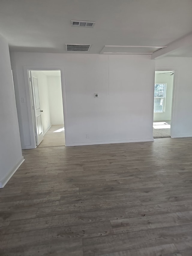 empty room with visible vents, baseboards, and wood finished floors