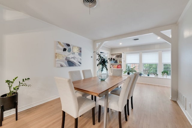 dining area featuring crown molding, visible vents, and light wood-type flooring