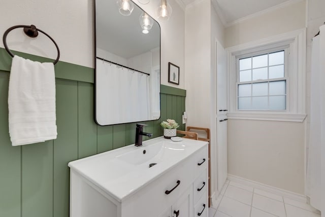 bathroom featuring vanity, ornamental molding, baseboards, and tile patterned floors