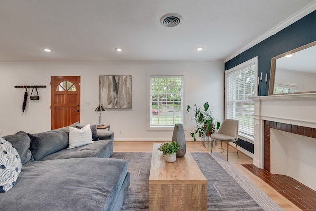 living area featuring visible vents, ornamental molding, and recessed lighting