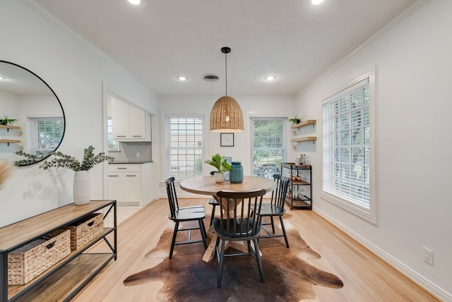 dining area with recessed lighting, ornamental molding, light wood-style flooring, and a wealth of natural light