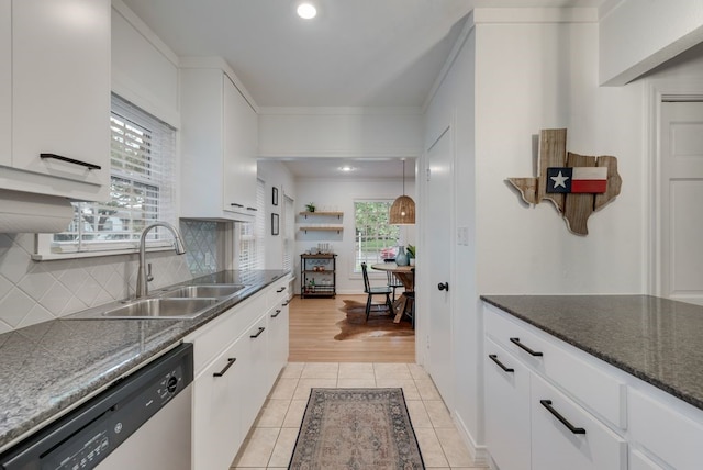 kitchen featuring backsplash, dishwasher, a sink, light tile patterned floors, and ornamental molding