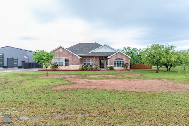 view of front of property featuring concrete driveway, a garage, an outbuilding, and a front yard