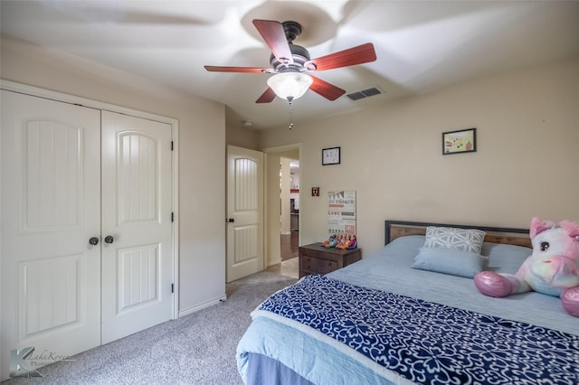 bedroom with a closet, visible vents, baseboards, ceiling fan, and light colored carpet