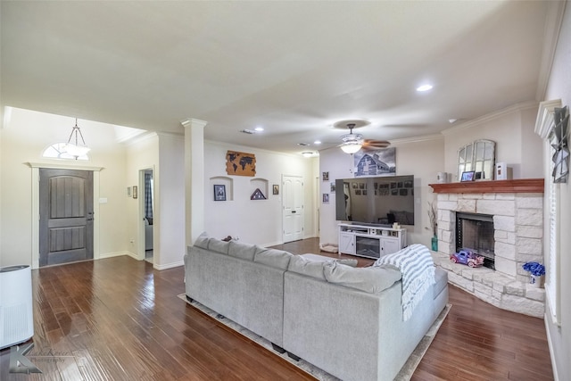 living room featuring a fireplace, ceiling fan, ornamental molding, and dark wood-style floors