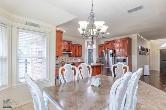 dining space with baseboards, a chandelier, and visible vents