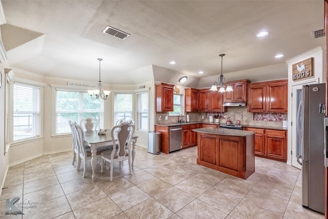 kitchen with stainless steel appliances, visible vents, decorative backsplash, a center island, and a notable chandelier