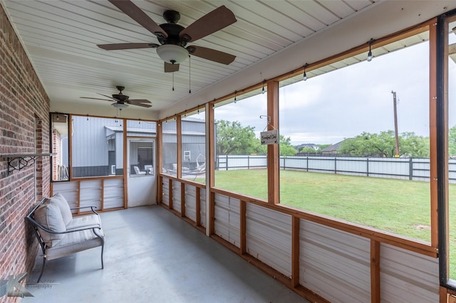 unfurnished sunroom featuring ceiling fan