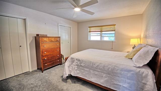 carpeted bedroom with a ceiling fan and two closets