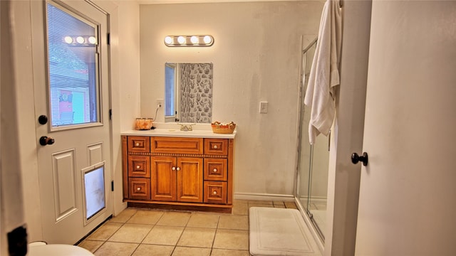 bathroom with vanity, tile patterned floors, baseboards, and a stall shower