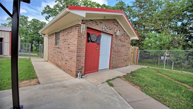 view of outbuilding with an outdoor structure, fence, and a gate