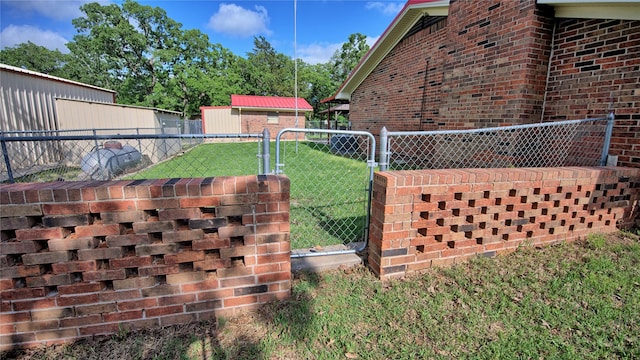 view of home's exterior with a lawn, a gate, brick siding, and fence