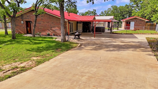 view of front of property with brick siding, fence, and a front yard