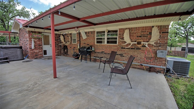 view of patio / terrace with central AC unit, a hot tub, fence, and grilling area