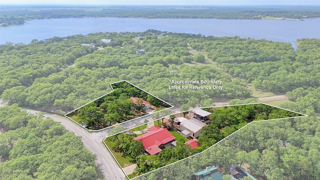 drone / aerial view featuring a water view and a wooded view