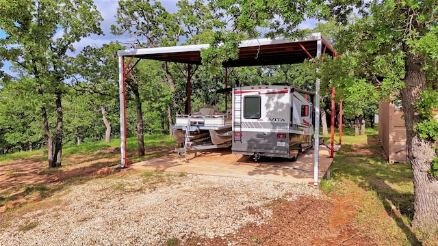 view of yard featuring a carport and dirt driveway