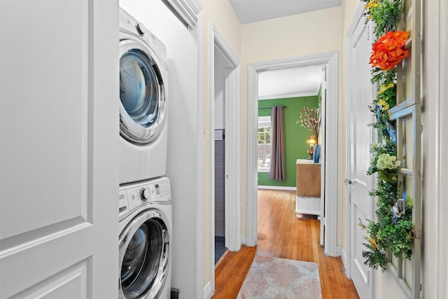 4204 Prescott Ave, Dallas, TX 75219 - washroom featuring baseboards, stacked washer and clothes dryer, and light wood-style floors