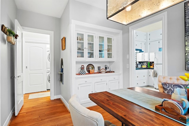 4204 Prescott Ave, Dallas, TX 75219 - dining space with stacked washer / drying machine, baseboards, and light wood-style floors
