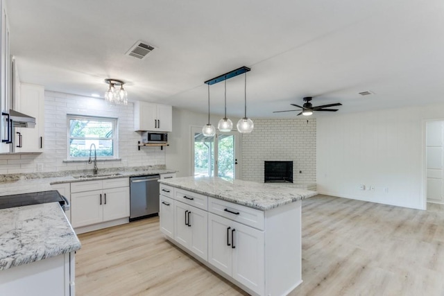 6148 Wrigley Way, Fort Worth, TX 76133 - kitchen featuring decorative backsplash, a brick fireplace, a sink, light wood finished floors, and stainless steel appliances
