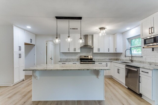 6148 Wrigley Way, Fort Worth, TX 76133 - kitchen with a sink, light wood-style flooring, wall chimney exhaust hood, stainless steel appliances, and visible vents