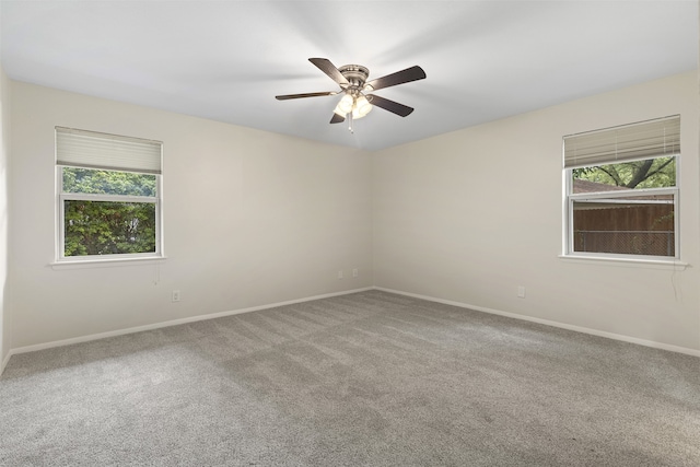carpeted spare room with baseboards and ceiling fan