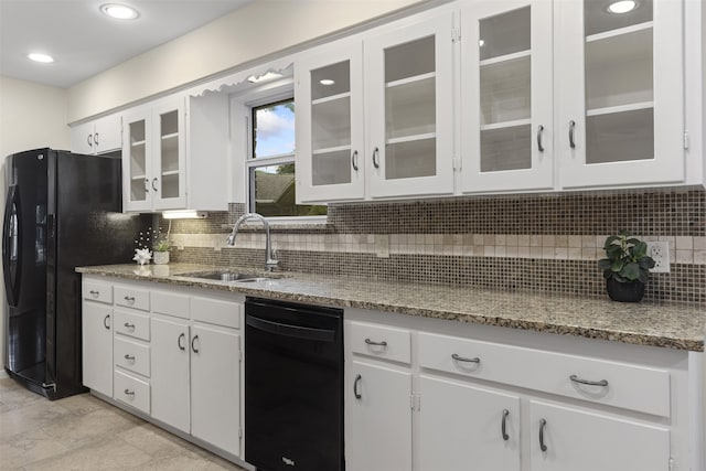 kitchen with a sink, backsplash, black appliances, and white cabinetry