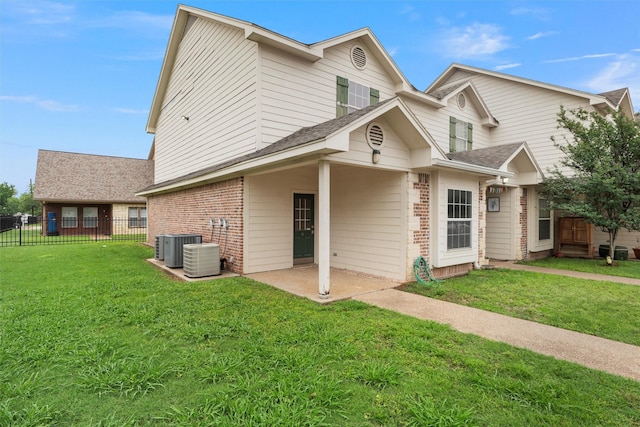 rear view of house with fence, a lawn, a patio area, and brick siding