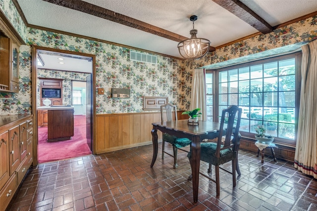 6555 Dartbrook Dr, Dallas, TX 75254 - dining area featuring a textured ceiling, healthy amount of natural light, a wainscoted wall, brick floors, and crown molding