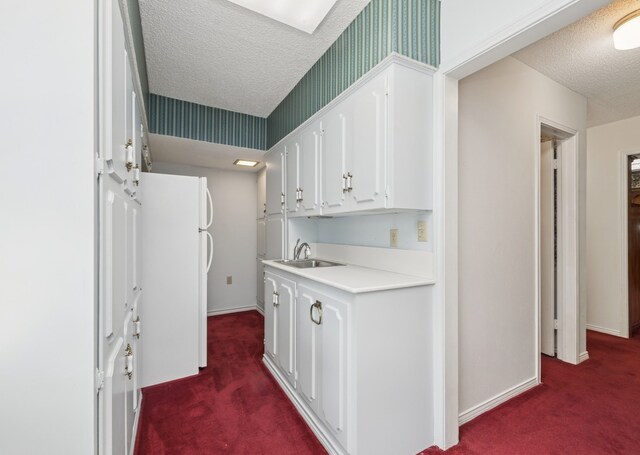 6555 Dartbrook Dr, Dallas, TX 75254 - corridor featuring a textured ceiling, dark carpet, a sink, and baseboards
