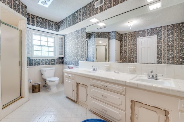 6555 Dartbrook Dr, Dallas, TX 75254 - full bath with wallpapered walls, a wainscoted wall, a textured ceiling, a stall shower, and toilet