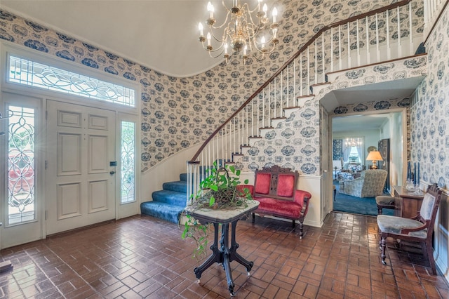 6555 Dartbrook Dr, Dallas, TX 75254 - foyer featuring wallpapered walls, brick flooring, wainscoting, stairs, and a chandelier