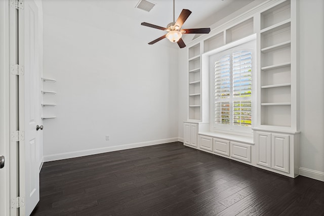 empty room featuring visible vents, baseboards, dark wood-type flooring, and ceiling fan