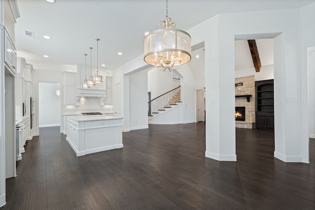 unfurnished living room with dark wood-style flooring, visible vents, stairs, a notable chandelier, and recessed lighting