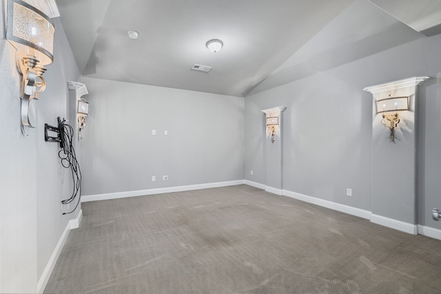 interior space featuring carpet floors, baseboards, visible vents, and lofted ceiling