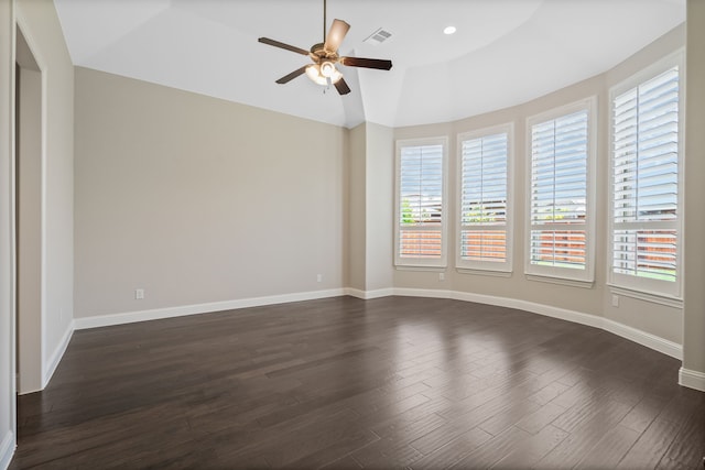 empty room featuring visible vents, lofted ceiling, baseboards, dark wood-type flooring, and a ceiling fan