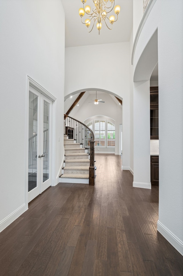 entryway featuring stairs, baseboards, french doors, arched walkways, and dark wood finished floors
