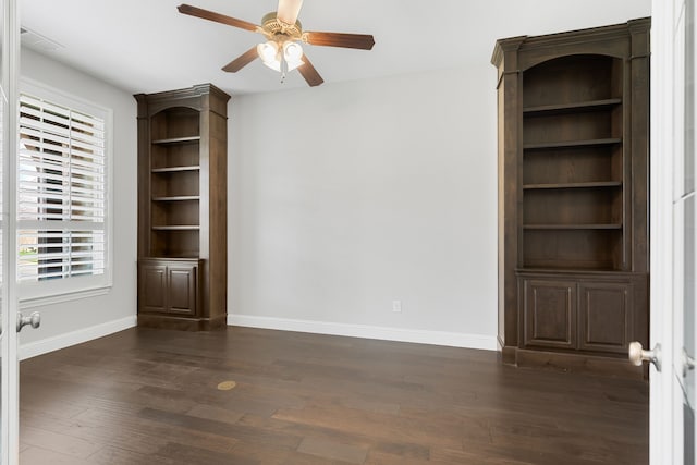 interior space featuring baseboards, ceiling fan, and dark wood-style floors
