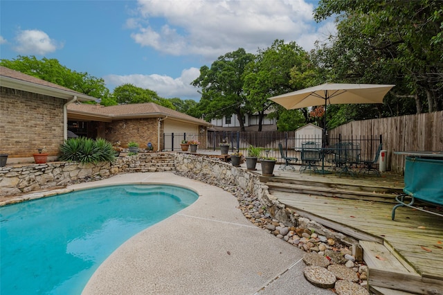 view of pool featuring a fenced backyard, a fenced in pool, and a deck
